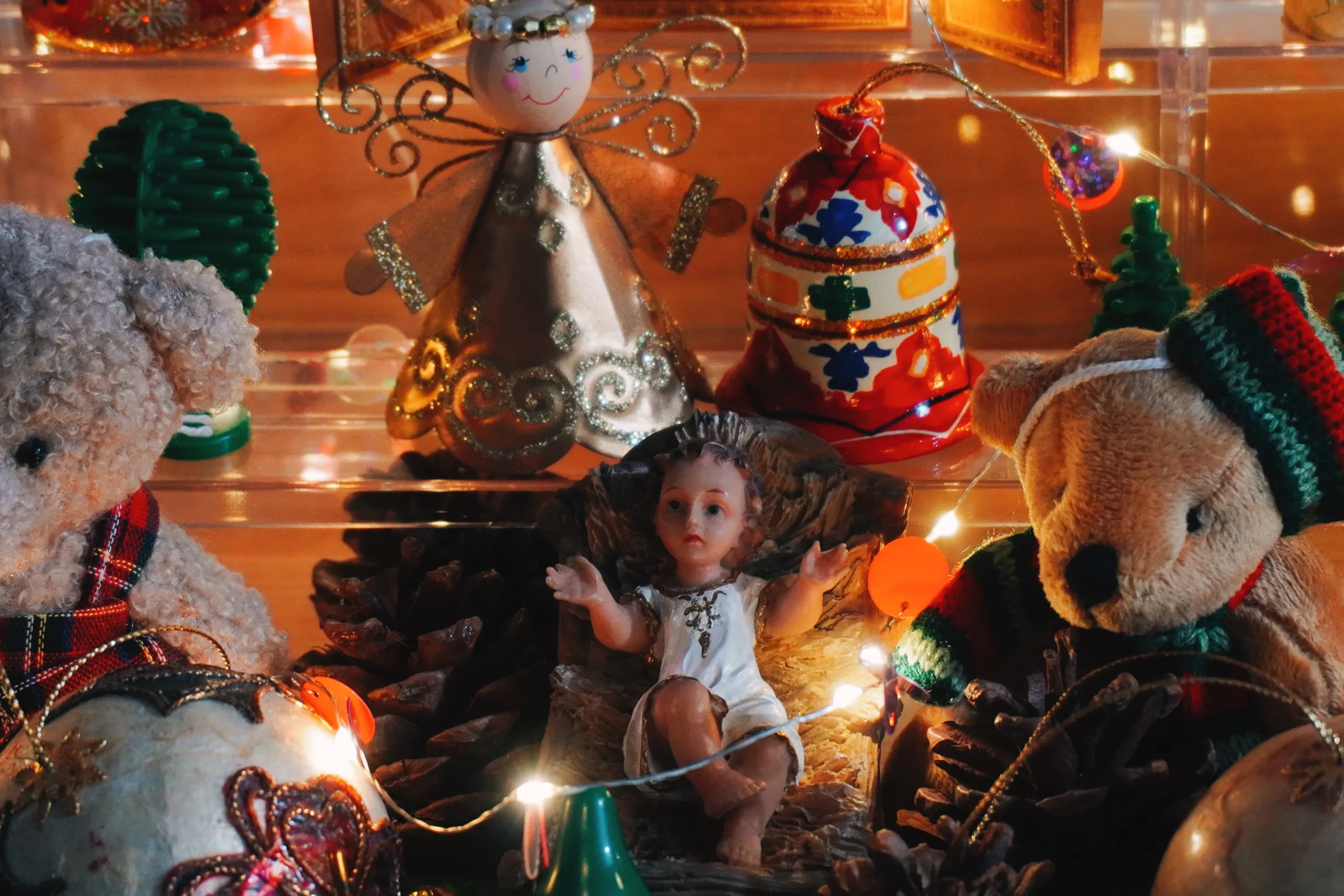 I originally wanted to place the baby Jesus farther up, but the figurine's heavy. To make it more safe and stable, I placed it at the bottom part instead. This gave me the idea to surround the Baby with holiday teddy bears!