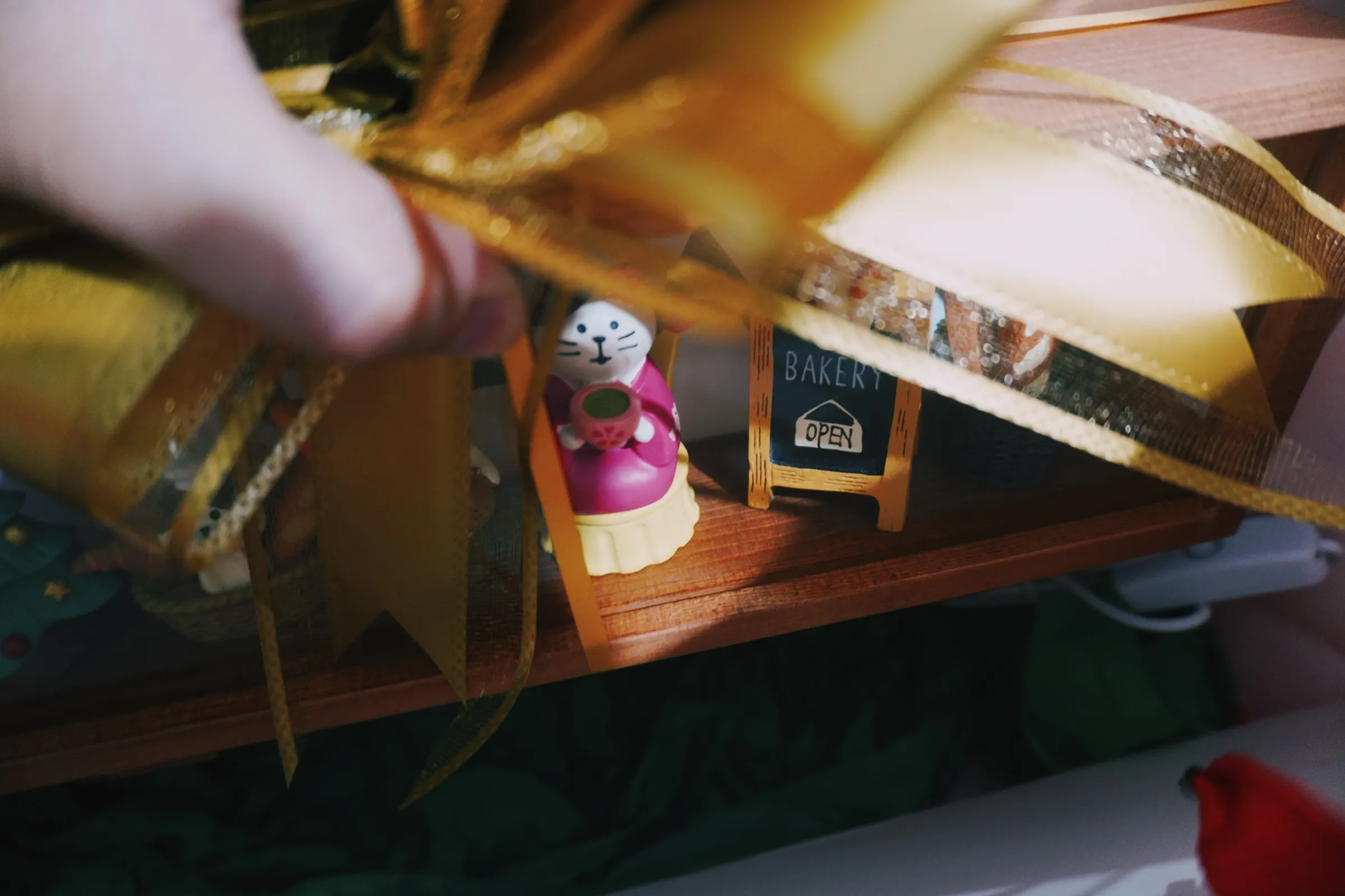 I taped the figures, added the prayer card, and removed the acrylics' protective film. Added the gold ribbons, nestled each one on bright green Japanese paper, and put them inside a bright red paper bag. Last step: initial on a stamp!